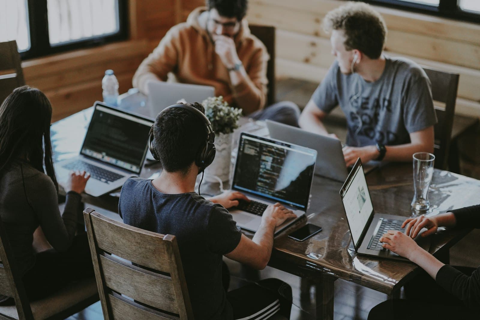 Team arbeitet gemeinsam an Laptops in einem Besprechungsraum